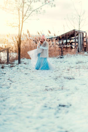 cute little girl in a fur coat with a clutch and a fluffy skirt snowy winterの写真素材