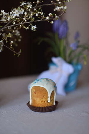 on the background of flowers and a rabbit Easter cake with blue ribbonの写真素材