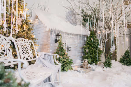 Winter fairy tale at the house in the forest - tree with lights and pine cones