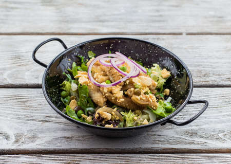 on a wooden stand with a plate of salad with meat and mushrooms barbecueの写真素材