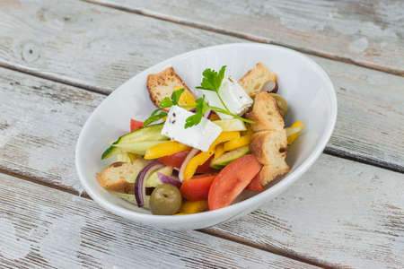 on a wooden base plate of Caesar salad with croutons and cheeseの写真素材