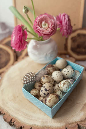 on wooden decks blue box with quail eggs and biscuits and beautiful flowers