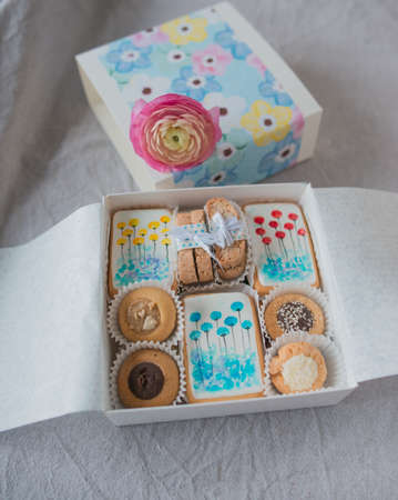 on a table decorated with a beautiful box with cookies and flowerの写真素材