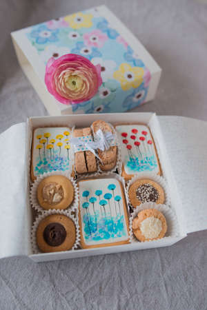 on a table decorated with a beautiful box with cookies and flowerの写真素材