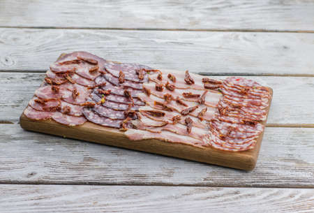 on the table wooden board with sausage meatsの写真素材