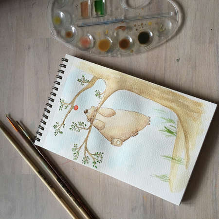 on the table with a picture album, clear palette with paints and a brushの写真素材