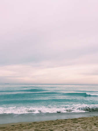 sand, surf in the sea on the horizon in a haze of shipsの写真素材