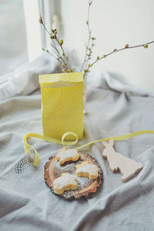 Paper gift bag with branches and cookies in the shape of a rabbitの写真素材