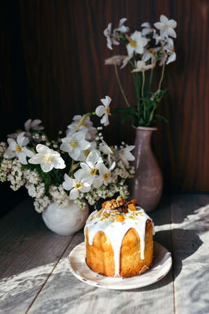 on a wooden table in the sun decorated Easter cakes and flowersの写真素材