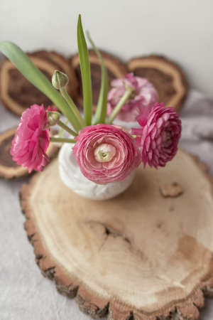 on a wooden stand decorative pink flowers in a vaseの写真素材