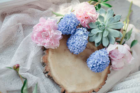 floral arrangement on a wooden stump pink peony and hyacinthの写真素材