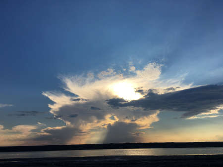 evening sunset over the lake with beautiful clouds and sunの写真素材