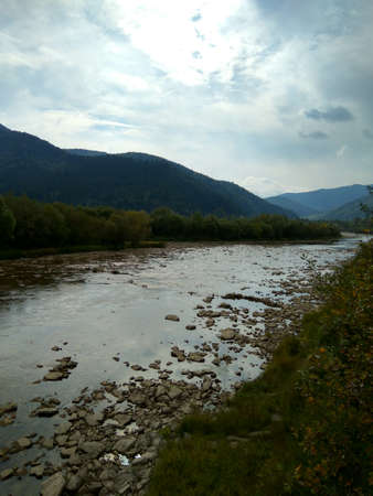 sky with clouds and rocks on the river in a mountain forestの写真素材