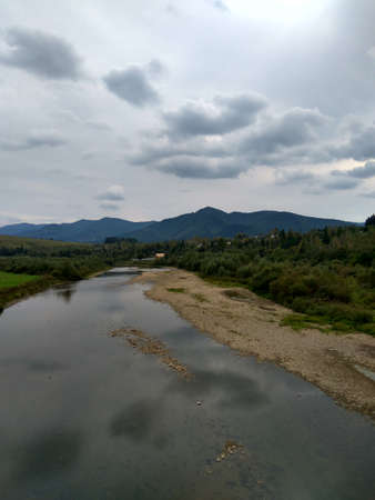 sky with clouds and rocks on the river in a mountain forest