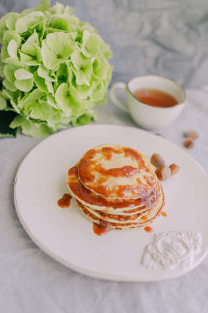 white cup and plate with pancakes, green hydrangeaの写真素材