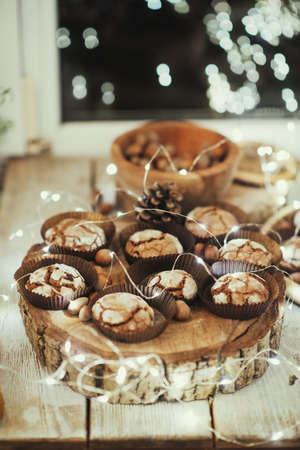 the window with the lights on a wooden table in the forms of cake and nutsの写真素材