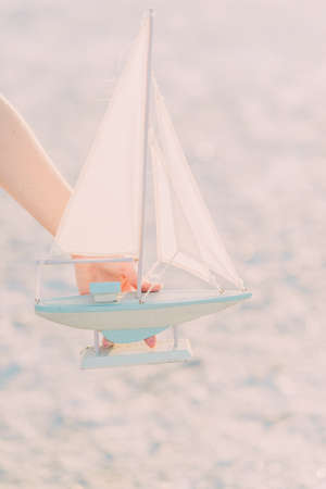 on the banks of the sun hand holds a sailboat layoutの写真素材