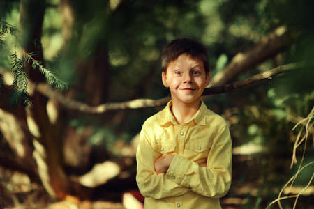 sunny day in the park cheerful boy in yellow shirtの写真素材