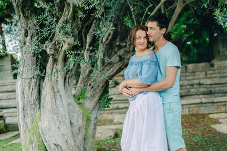 Camping in the summer under a tree Young couple gently huggingの写真素材