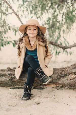 poses in the autumn forest beautiful girl with long hair in a hat and a coat with fur