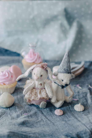 soft, fluffy, white stitched toys with their own hands and a delicious dessertの写真素材