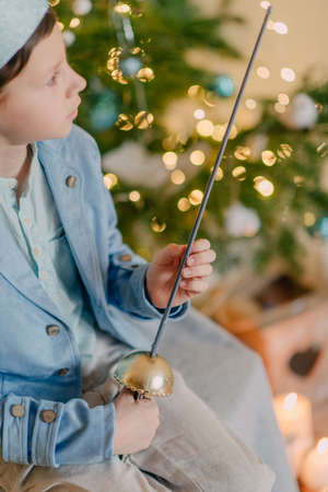 near beautiful Christmas tree little boy in a blue prince dressed in a crown and with a swordの写真素材