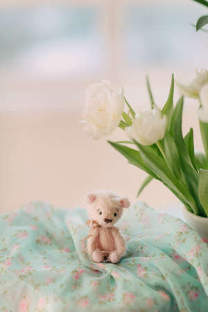 teddy bear and a bouquet of white spring flowersの写真素材