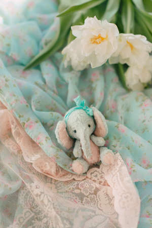 plush elephant and a bouquet of white spring flowers