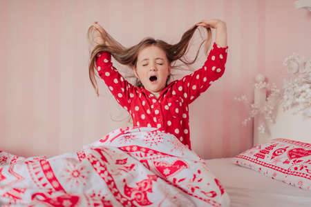 girl in red pajamas sleeping in bed