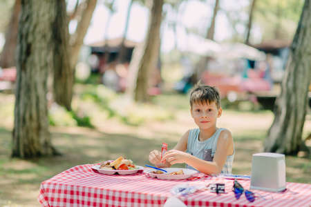 Boy eats in a summer parkの写真素材