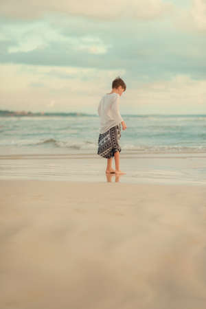 On a hot day, a little boy on the beach is on the beachの写真素材