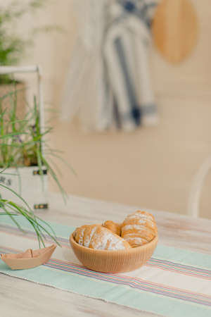 On a table on a blackboard in a wooden bowl fresh croissantsの写真素材