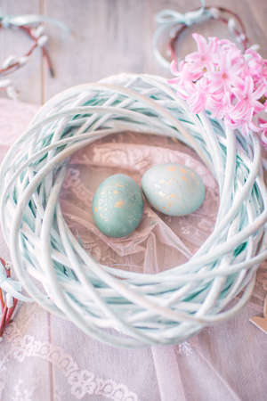 On a wooden blue background Easter eggs in a wicker nest and hyacinthの写真素材