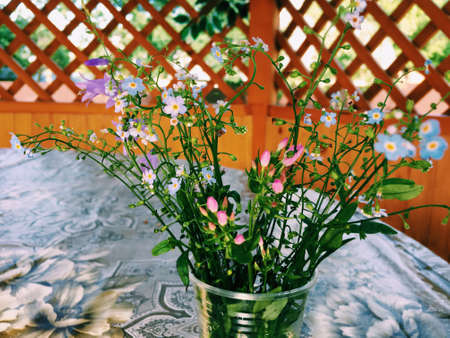 on the table in the glass delicate bouquet of wild flowersの写真素材