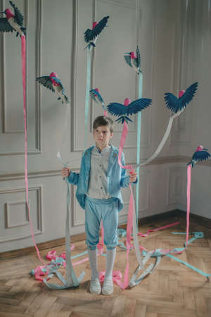 in the Studio the boy in the blue suit with birds and colored ribbonsの写真素材