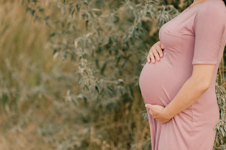 the pregnant girl on the river bank on a sunsetの写真素材