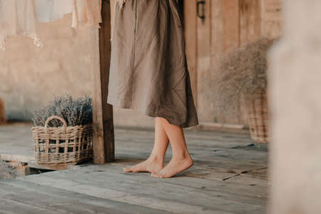Lavender basket in a rustic courtyard near the feet of a girlの写真素材