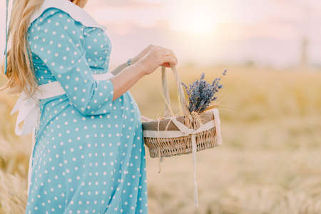 the pregnant girl on the river bank on a sunsetの写真素材