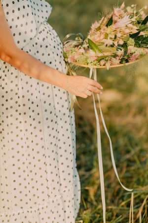 the pregnant girl on the river bank on a sunsetの写真素材