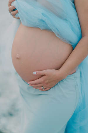 the pregnant girl on the river bank on a sunsetの写真素材