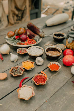 wooden table with vegetables and spicesの写真素材
