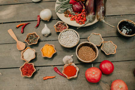 Wooden table with vegetables and spicesの写真素材