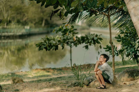 the boy is playing on the rocks on the ocean shoreの写真素材