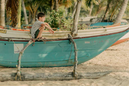 the boy is playing on the rocks on the ocean shoreの写真素材