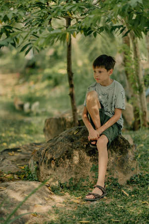 the boy is playing on the rocks on the ocean shoreの写真素材