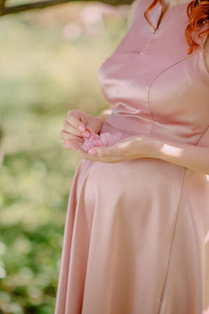 the pregnant girl on the river bank on a sunsetの写真素材