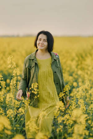 in spring, in a blooming garden, a woman in a jumpsuit with a wicker basket is posing