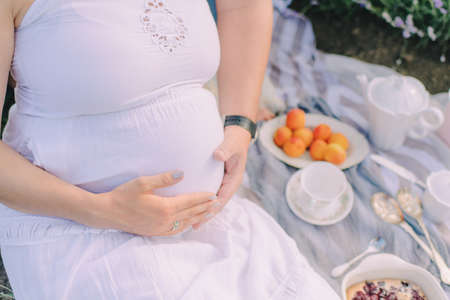 the pregnant girl on the river bank on a sunsetの写真素材