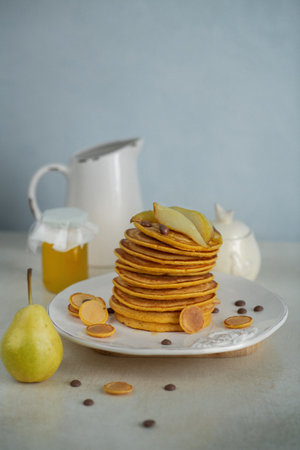 Pastries, pancakes with pumpkin and pear in caramel in the background honeyの写真素材