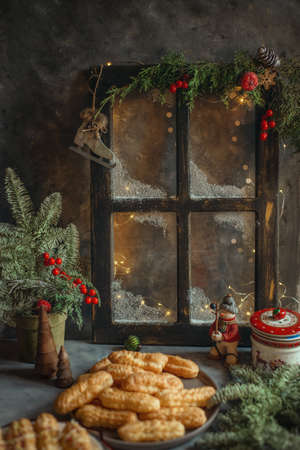 Dessert cake with cream in the New Year and Christmas decor on the background of the windowの写真素材